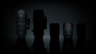 Five Canon lenses side by side over black background, two are illuminated, the other three are silhouettes